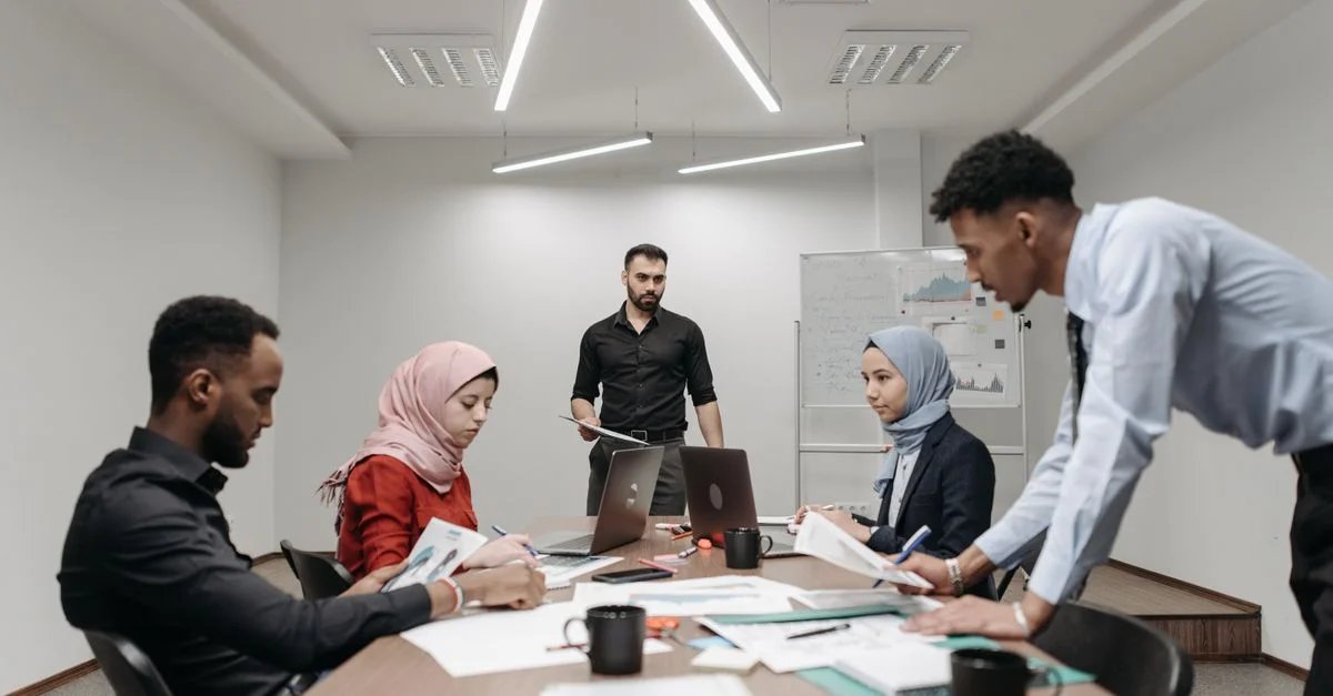 Profesionales diversos participan en una reunión estratégica en un entorno de oficina moderno, fomentando el trabajo en equipo y la innovación.