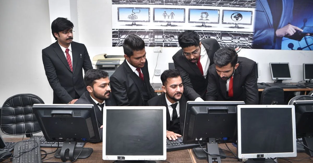 Grupo de profesionales colaborando en trabajos informáticos en una oficina moderna.