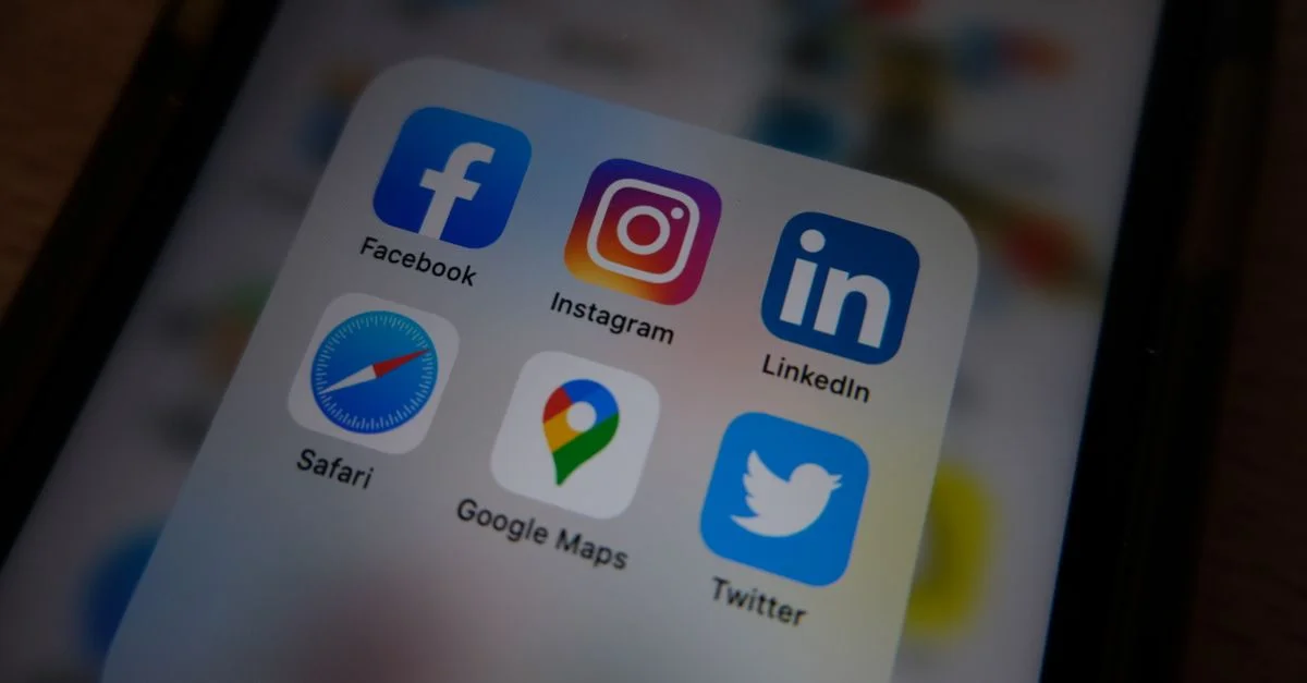 Vista cercana de los íconos populares de aplicaciones de redes sociales en la pantalla de un smartphone.