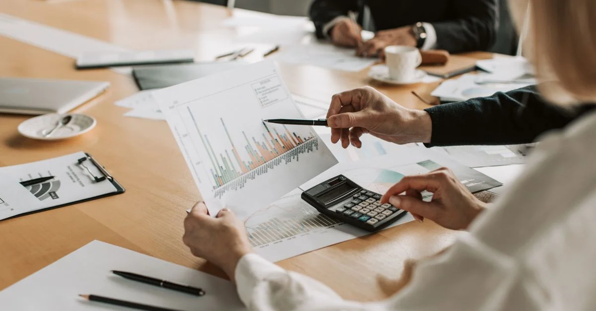 Profesionales revisando gráficos y tablas financieros durante una reunión.