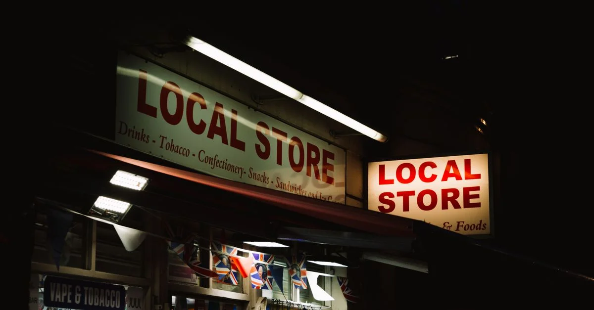 Una tienda local urbana brillando con letreros de neón durante la noche, capturando la esencia de la vida nocturna de la ciudad.
